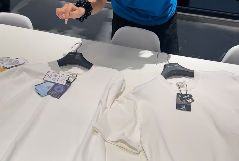 Two white tee samples laid side by side on a table and compared